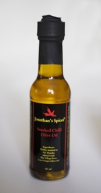 Tall round clear glass sealed bottle containing Jonathan's Spices smoked chilli olive oil