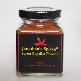 A square shaped glass jar with a black, red and yellow label containing Jonathan's Spices sweet spanish paprika powder