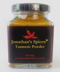A square shaped glass jar with a black, red and yellow label containing Jonathan's Spices Turmeric Powder