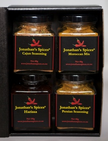 A black folding cardboard box that opens to reveal a four jar variety of Jonathan's Spices